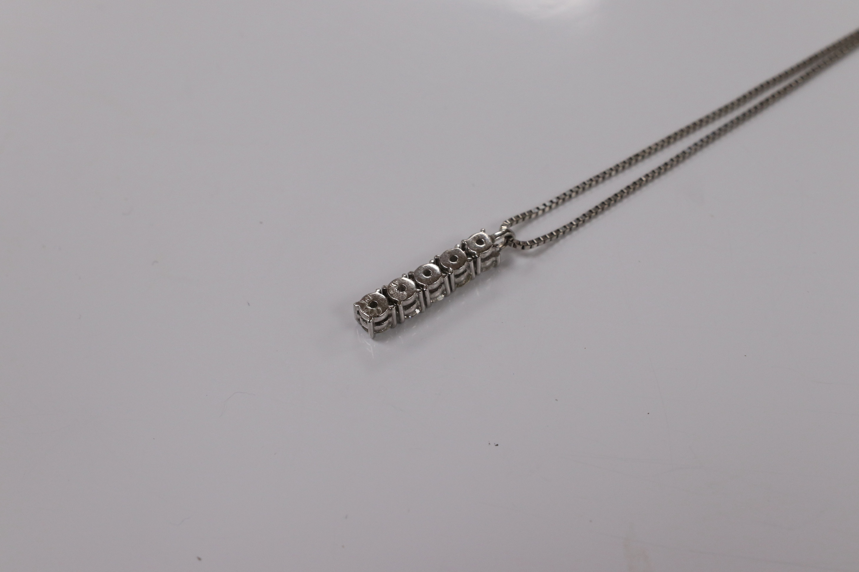 A modern white metal (stamped PT900) and five stone diamond set line pendant, on white metal (stamped pt850), overall 49cm, gross weight 4.9 grams. Condition - fair to good